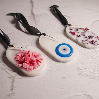 Radiate's pack of three wax tablets with floral design, eye eye design, and rose petal designs on table